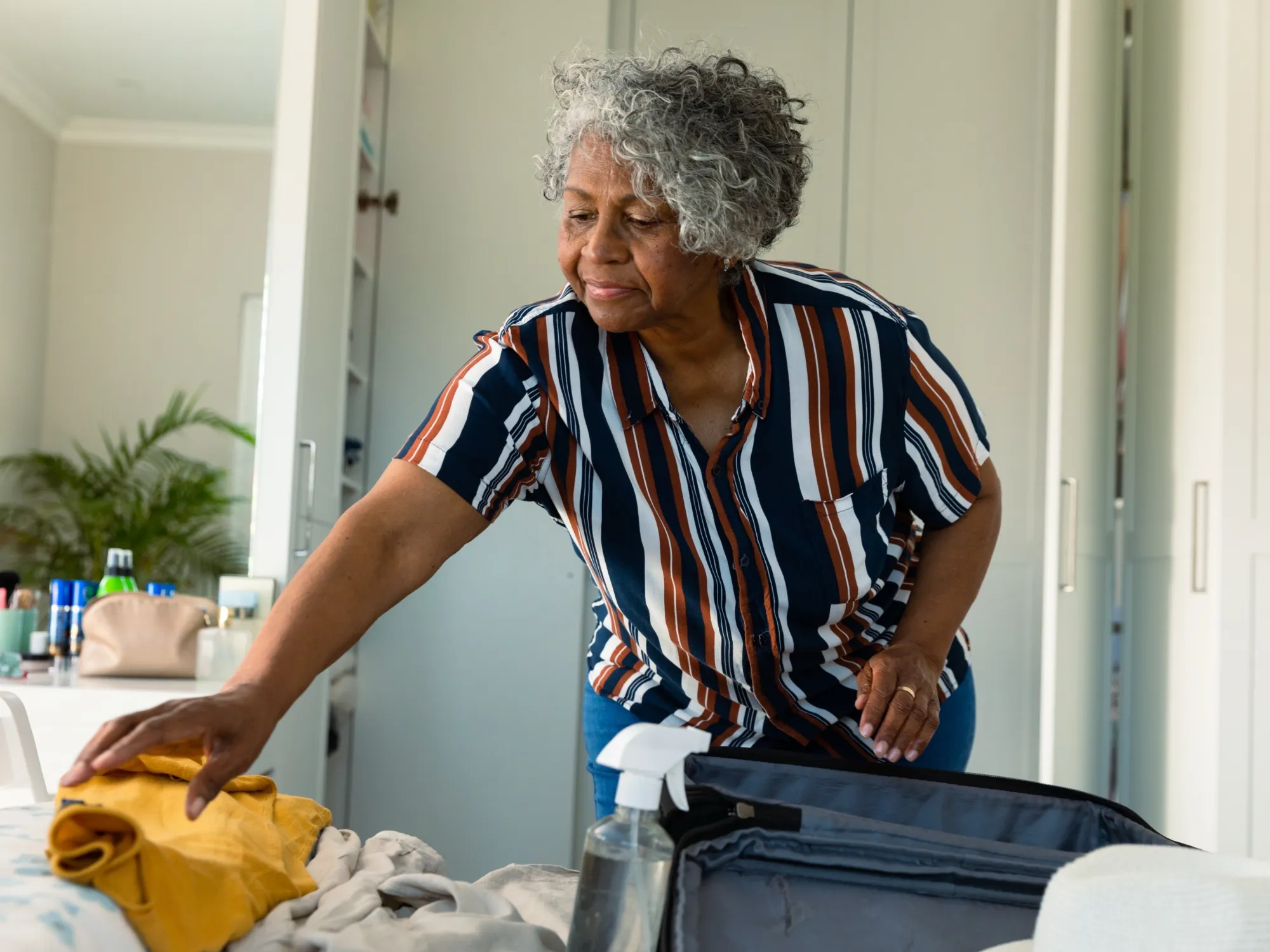 Focused african american senior woman packing suit 2025 04 04 14 06 21 utc